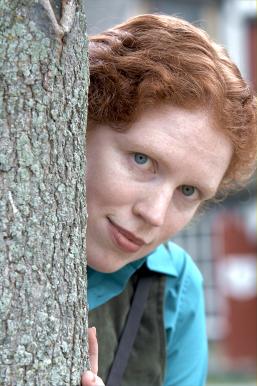 Tamara plays hide'n'seek behind a tree.