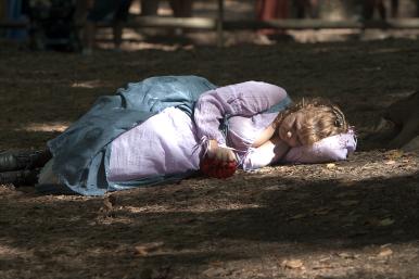 Exhausted, a patron takes a nap on the forest floor.